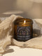 Amber glass jar with Guardian Flame label featuring a metallic wolf and flame motifs in pink and gold. Spicy cinnamon, vanilla, and gurjun balsam candle. 9 oz soy candle by Grimoire & Goblet.